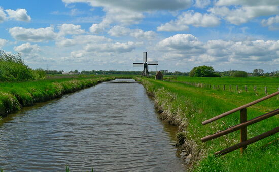 Fluss mit Windmühle in der Distanz