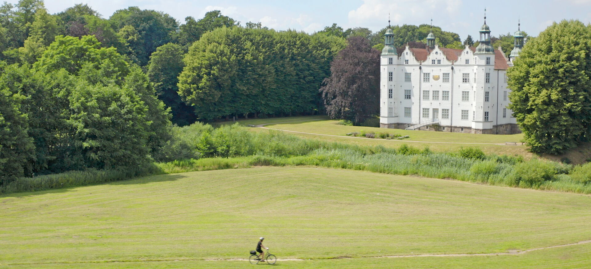 Schloss Ahrensburg mit Fahrradfahrer:in