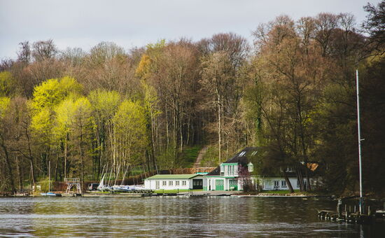 weiß-grünes Haus am Ufer eines Sees