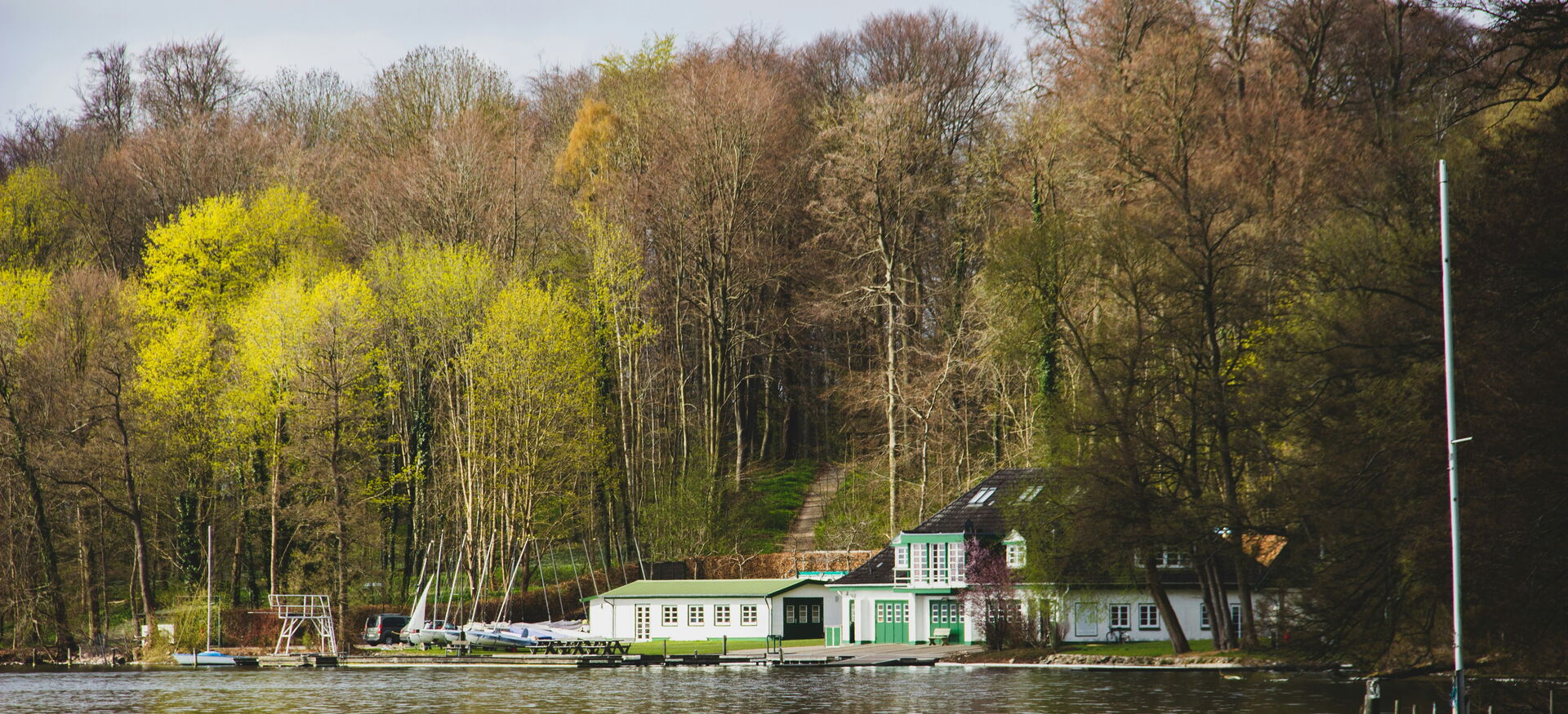 weiß-grünes Haus am Ufer eines Sees